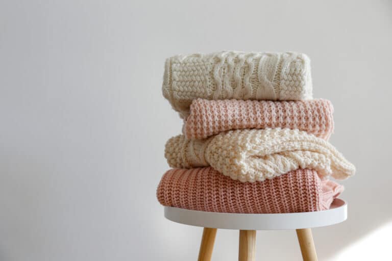 Wollpullover-Wäschestapel auf kleinem Tisch
